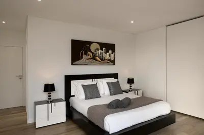 a white bedroom with a bed with two night stands at Villa Panorâmica III in Arco da Calheta
