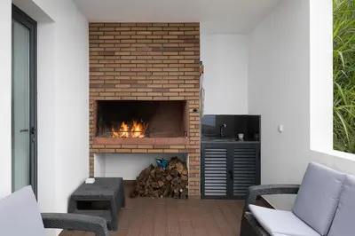 a fireplace in a living room with a fire place at Villa Panorâmica III in Arco da Calheta