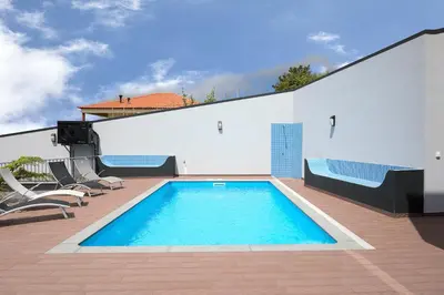 a swimming pool on the side of a building at Villa Panorâmica III in Arco da Calheta