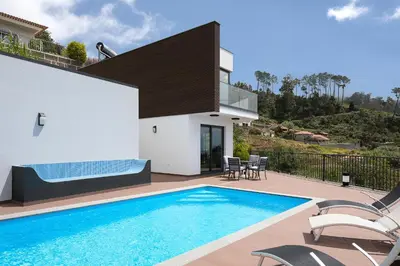 a villa with a swimming pool and a house at Villa Panorâmica III in Arco da Calheta