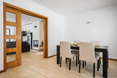 a dining room with a black table and white chairs at Til Home by Homie in Funchal