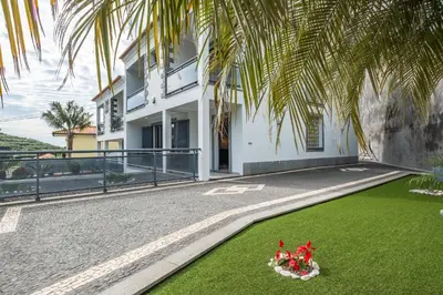 a house with a green lawn in front of it at Til Home by Homie in Funchal