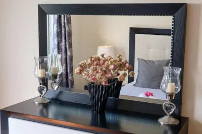 a table with a vase of flowers in front of a mirror at GuestReady - Oasis Getaway in Madeira in Caniço
