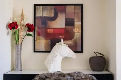 a table with a white horse statue and a vase with flowers at GuestReady - Oasis Getaway in Madeira in Caniço