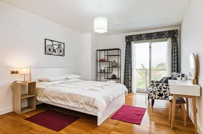 a white bedroom with a large bed and a desk at THE OLD CHAPEL HOUSE in Funchal