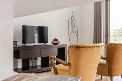 a living room with a desk with a tv and two chairs at THE OLD CHAPEL HOUSE in Funchal