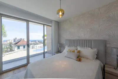 a bedroom with a large bed and a large window at The Queen Apartment By Sam Houses in Funchal