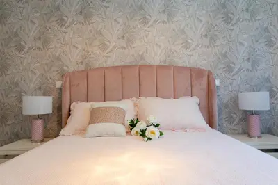 a bed with a pink head board with flowers on it at The Queen Apartment By Sam Houses in Funchal