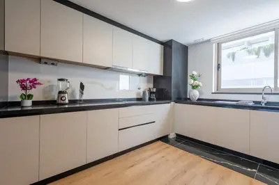 a kitchen with white cabinets and a window at The Queen Apartment By Sam Houses in Funchal