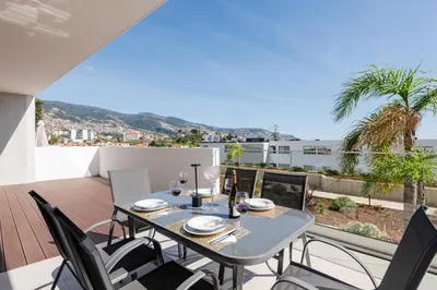 a dining table and chairs on the balcony of a house at The Princess Apartment By Sam Houses in Funchal
