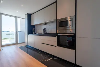 a kitchen with stainless steel appliances and a large window at The Princess Apartment By Sam Houses in Funchal