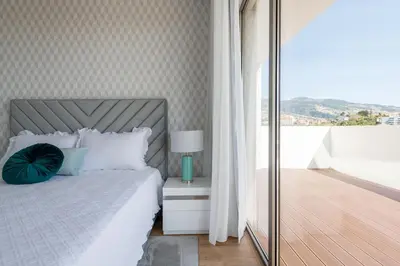 a bedroom with a bed with a lamp and a balcony at The Princess Apartment By Sam Houses in Funchal