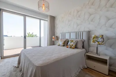 a bedroom with a large bed and a large window at The Prince Apartment By Sam Houses in Funchal