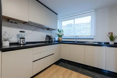 a kitchen with white cabinets and a window at The Prince Apartment By Sam Houses in Funchal