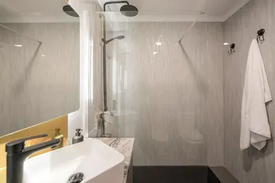 a bathroom with a white sink and a shower at Doca do Cavacas I by An Island Apart in Funchal