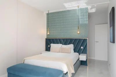 a bedroom with a bed and a blue headboard at Doca do Cavacas I by An Island Apart in Funchal