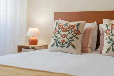 a bedroom with a bed with pillows and a lamp at Casa da Cidade by An Island Apart in Funchal