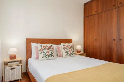 a bedroom with a large bed with a wooden headboard at Casa da Cidade by An Island Apart in Funchal