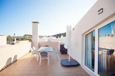 a patio with a table and chairs on a balcony at Casa Sol in Burgau