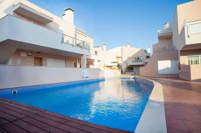 a swimming pool in front of a building at Casa Sol in Burgau