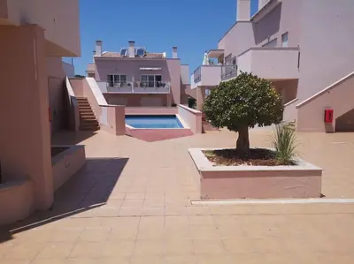 a courtyard with a tree in the middle of a building at Casa Sol in Burgau