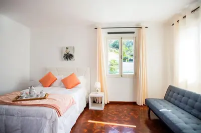 a bedroom with a bed and a couch and a window at Dream Paradise in Água de Pena