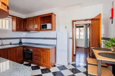 a kitchen with wooden cabinets and a black and white tile floor at Dream Paradise in Água de Pena