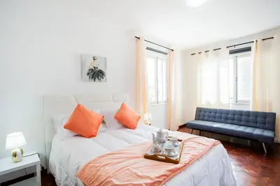 a bedroom with a bed with orange pillows and a couch at Dream Paradise in Água de Pena