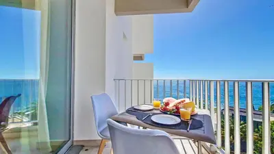 a balcony with a table with a view of the ocean at Ponta Beachside by LovelyStay in Funchal