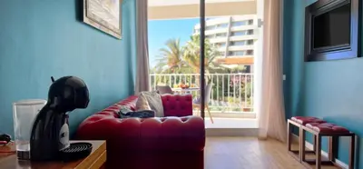 a living room with a red couch and a window at Ponta Beachside by LovelyStay in Funchal