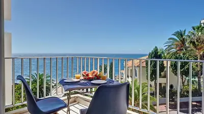 a balcony with a table and chairs and the ocean at Ponta Beachside by LovelyStay in Funchal