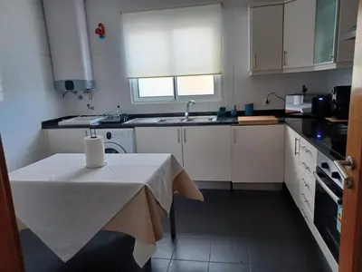 a small kitchen with a table and a sink at Ocean Paradise Til II in Funchal