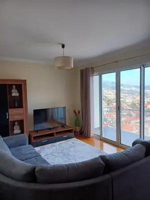 a living room with a couch and a flat screen tv at Ocean Paradise Til II in Funchal