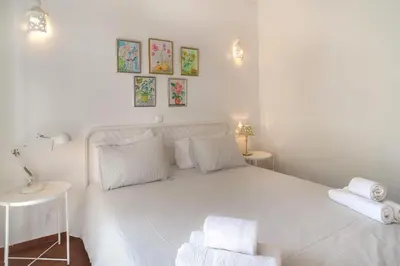 a white bedroom with a white bed with towels on it at Casa da Praia in Luz