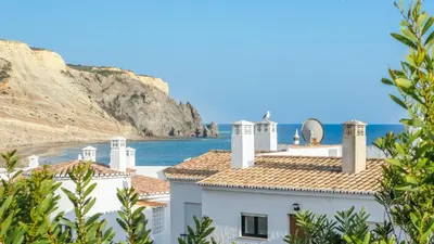 a white building with a view of the ocean at Casa da Praia in Luz