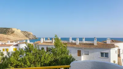 a view of a building with the ocean in the background at Casa da Praia in Luz