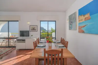 a dining room with a wooden table and chairs at Casa da Praia in Luz