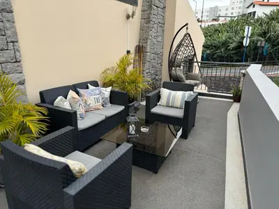 a patio with two couches and a chair at Alforra Residence 1-T2-centro-praias-Levadas in Câmara de Lobos