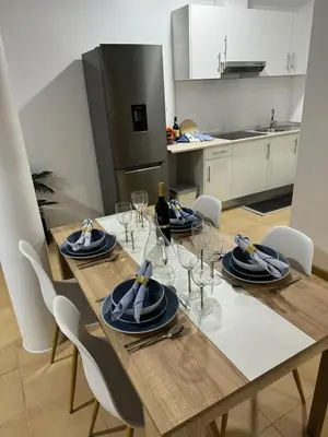 a dining room table with chairs and a kitchen at Alforra Residence 1-T2-centro-praias-Levadas in Câmara de Lobos