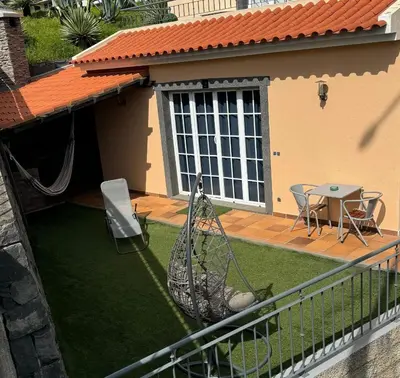 a patio with a hammock and a table on a balcony at Alforra Residence 1-T2-centro-praias-Levadas in Câmara de Lobos