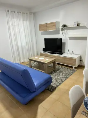 a living room with a blue couch and a tv at Alforra Residence 1-T2-centro-praias-Levadas in Câmara de Lobos