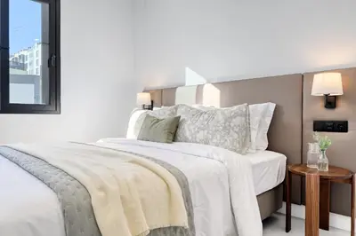 a bedroom with a bed with white sheets and a window at Beco Santa Emilia 2H, a Home in Madeira in Funchal