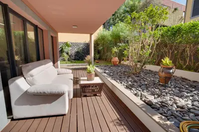 a patio with a white chair and a rock garden at Sunscape T2 in Funchal