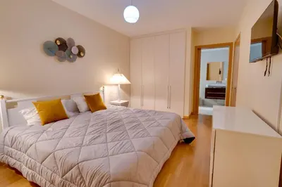 a bedroom with a large bed with yellow pillows at Sunscape T2 in Funchal