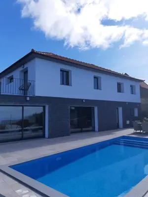 a house with a swimming pool in front of it at Casa dos Avós in Fajã da Ovelha
