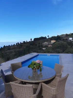 a table with a vase of flowers on a patio at Casa dos Avós in Fajã da Ovelha