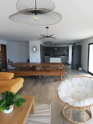 a living room with wooden tables and a large chandelier at Casa dos Avós in Fajã da Ovelha