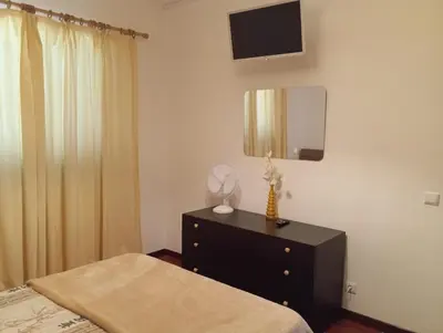 a bedroom with a bed and a dresser with a mirror at Sunrise Holidays in Porto Santo