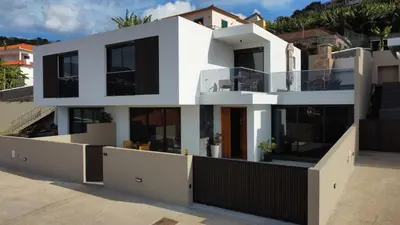 a white house with black windows at Allure Alannas Villa by LovelyStay in Funchal