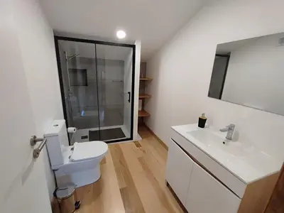 a bathroom with a toilet and a sink and a mirror at Casa Vicente in Arco da Calheta